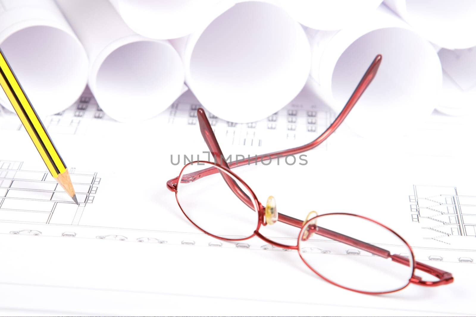 Blueprints, glasses and pencil