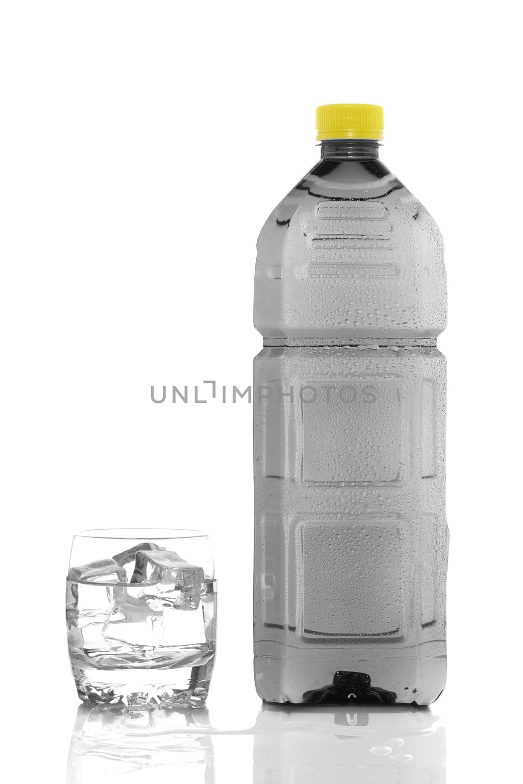 Bottle and glass of mineral water with droplets