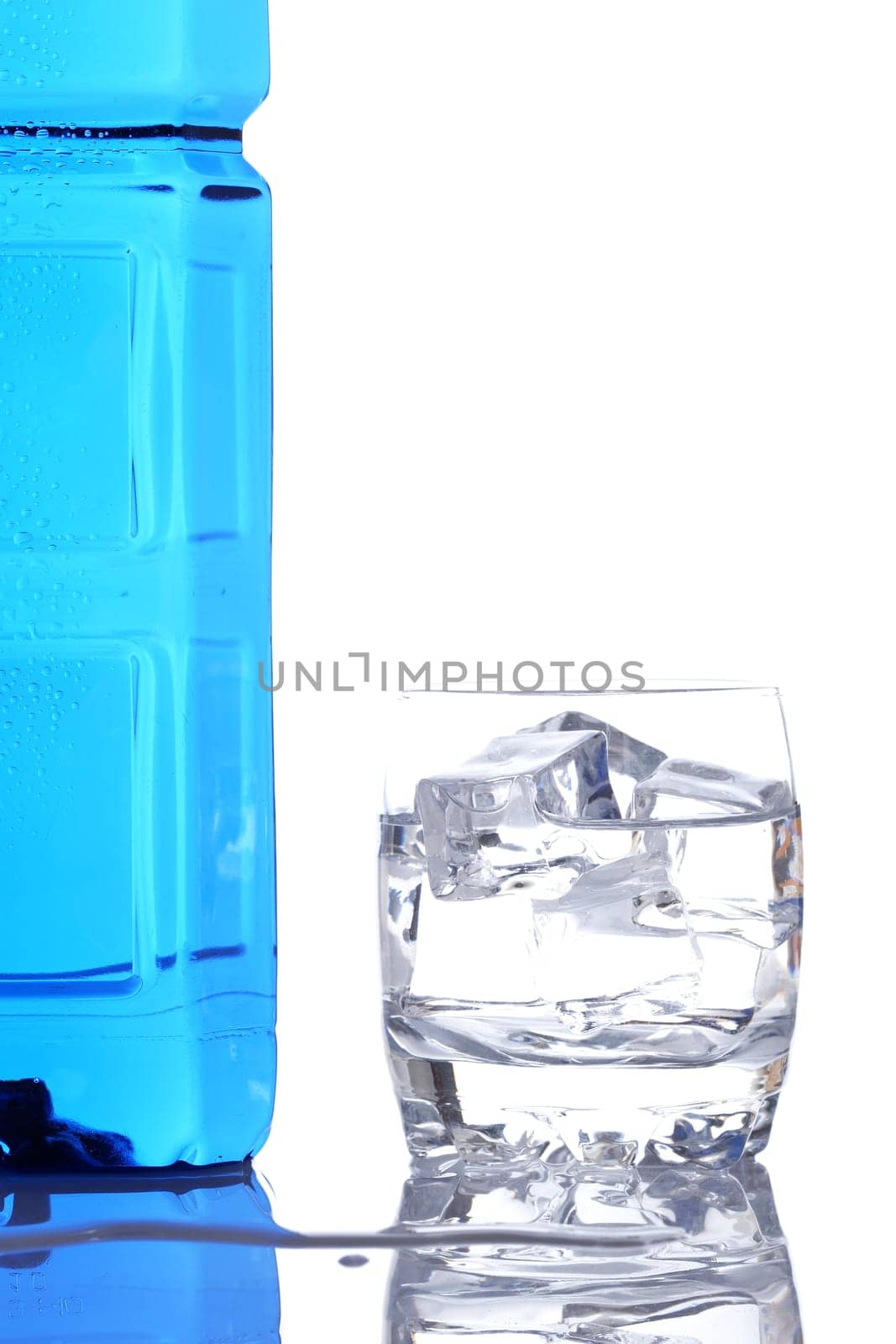 Bottle and glass of mineral water with droplets