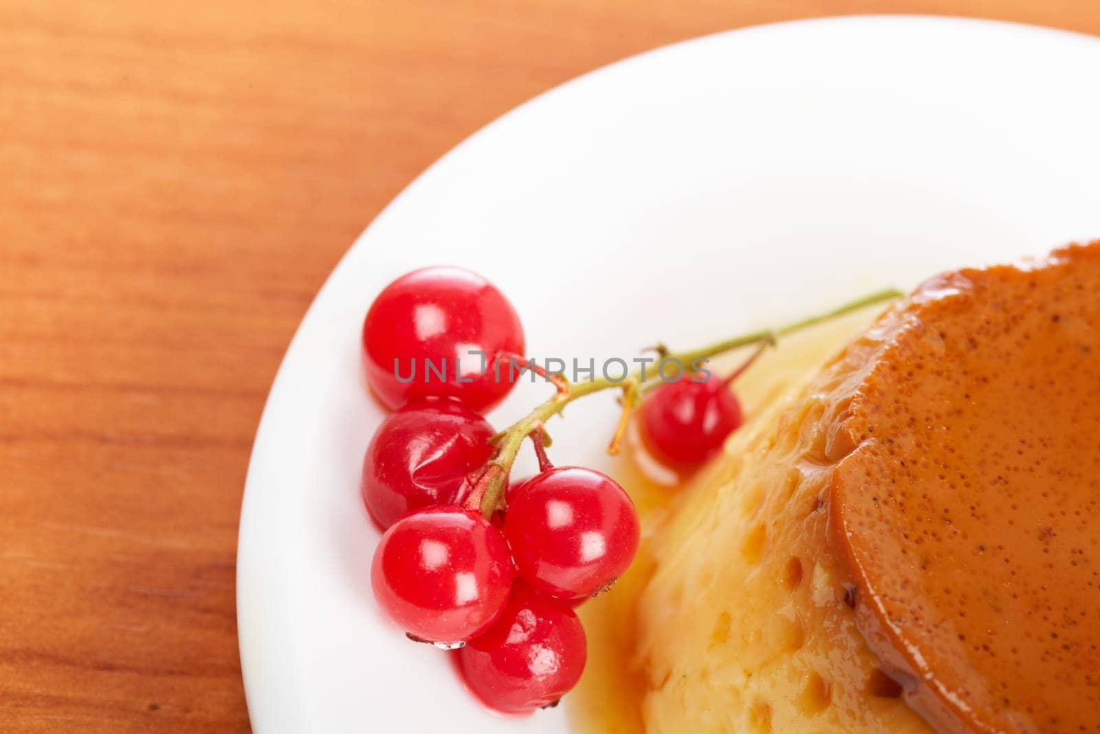 Cream caramel dessert with red currants