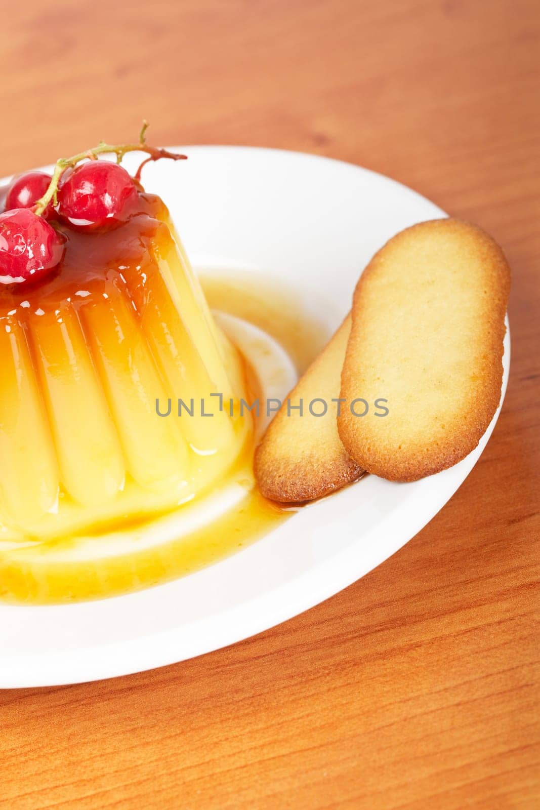Cream caramel dessert with red currants and cookies