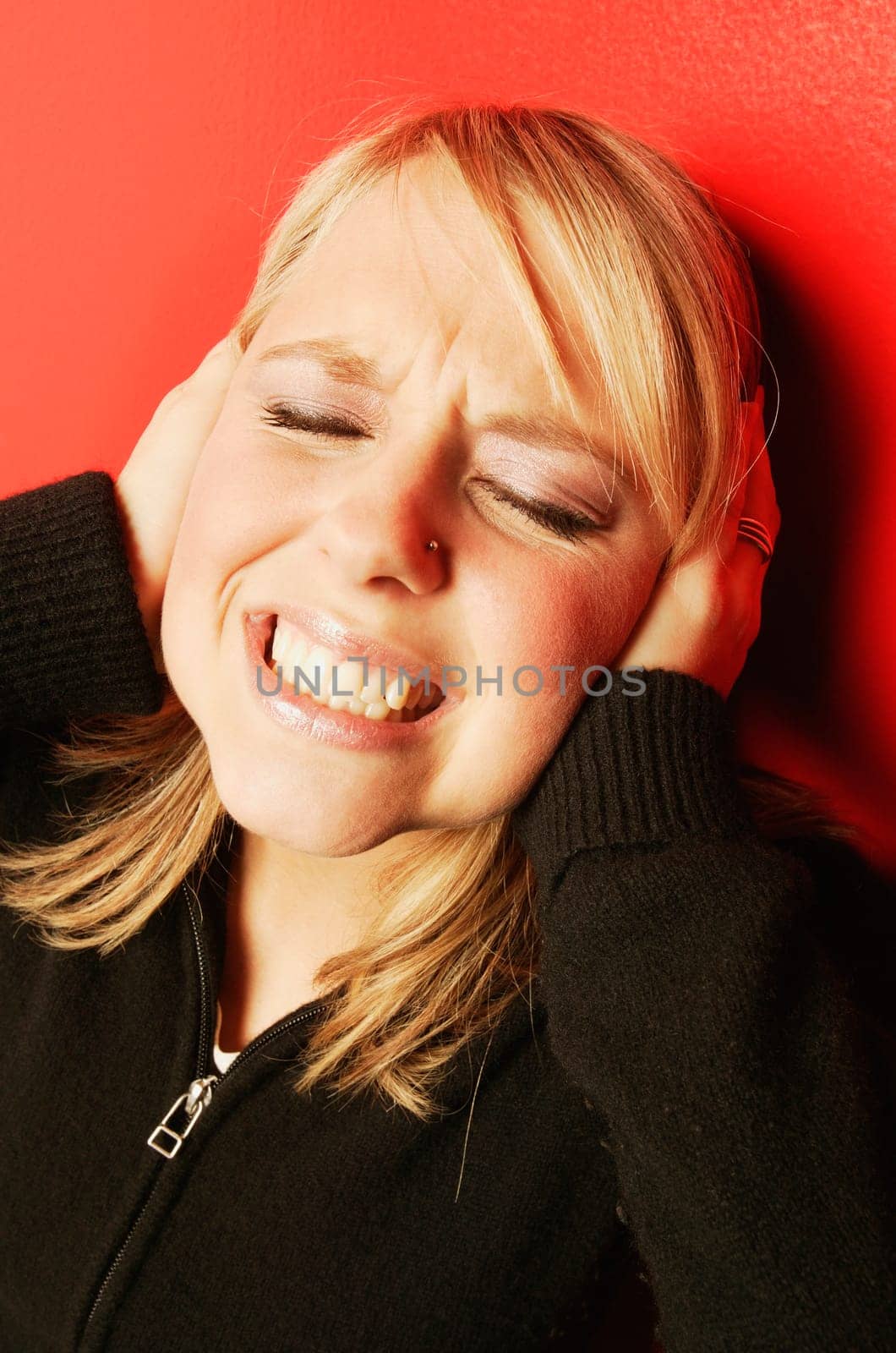 Woman holds hands over her ears