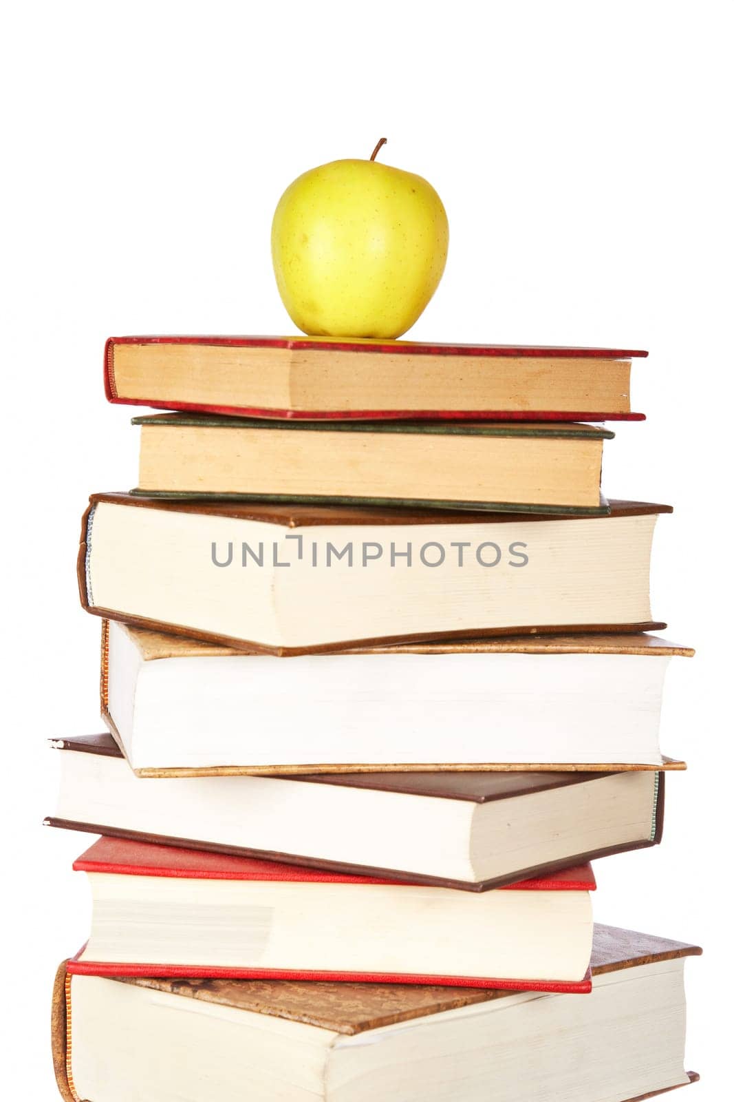Yellow apple on pile of books