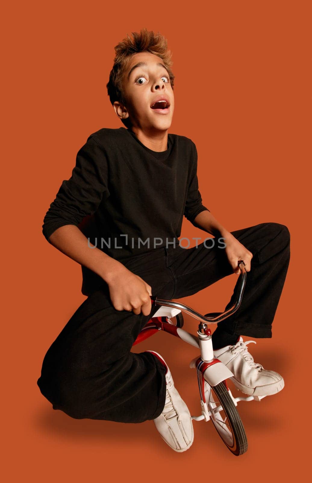 Teenage boy on tiny bicycle