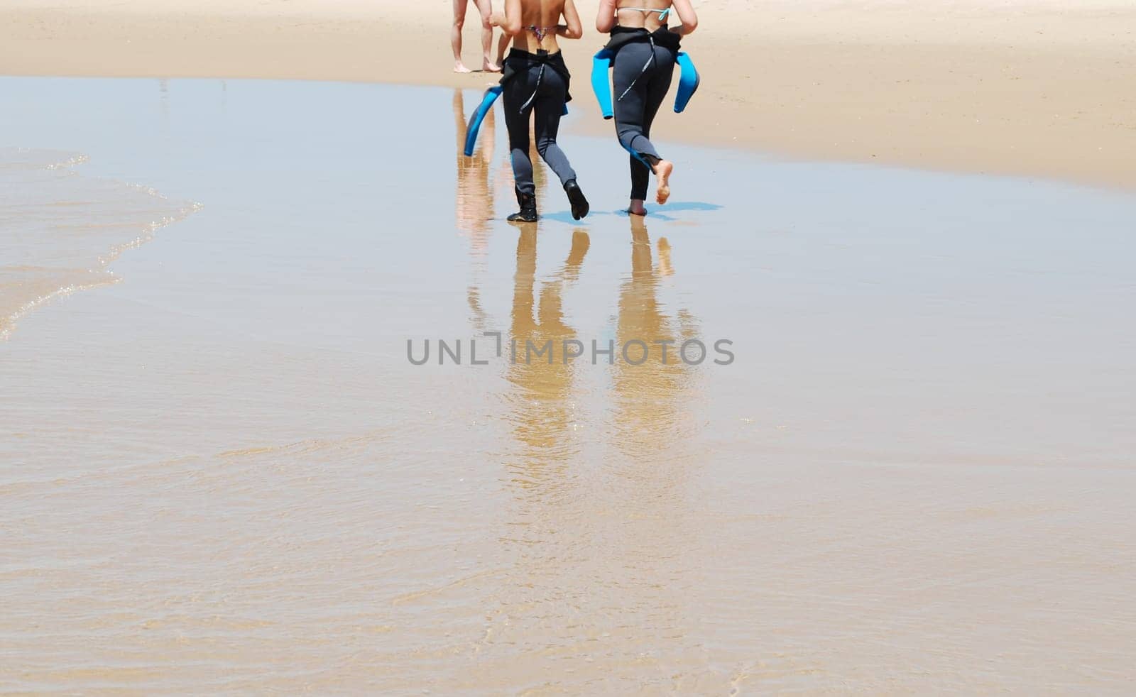 Young surfers walking on the beach