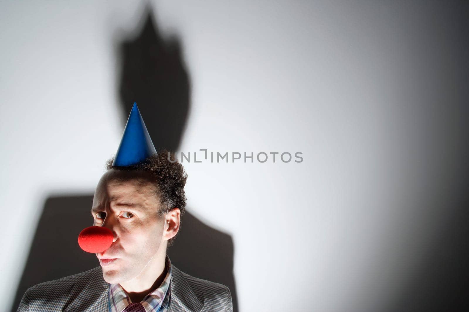 Man wearing clown's nose and hat