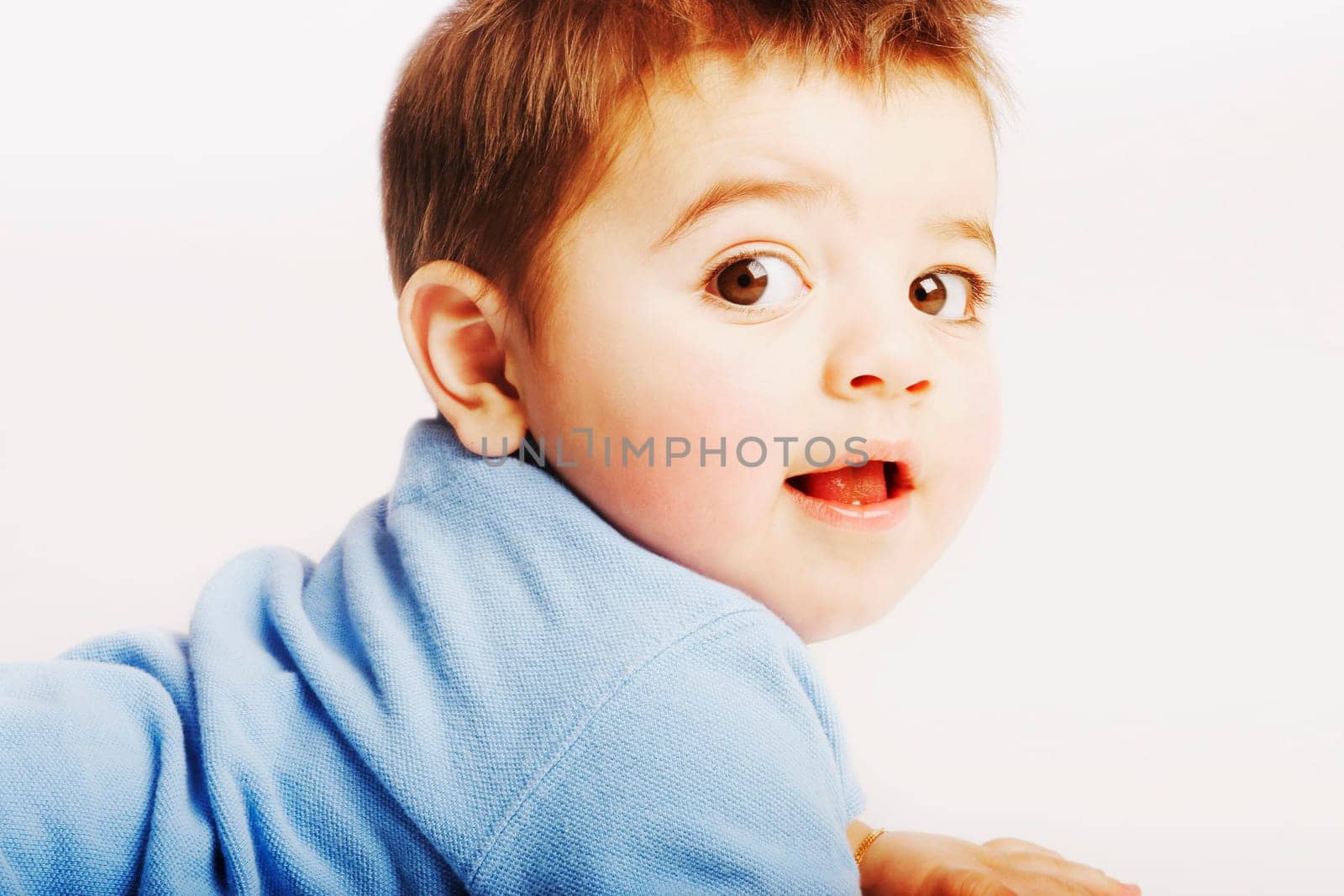 A baby looks over shoulder