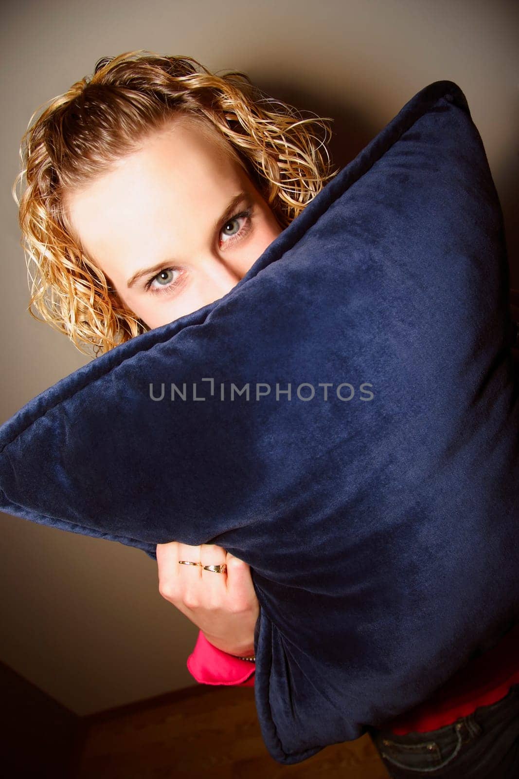Girl hiding behind a pillow