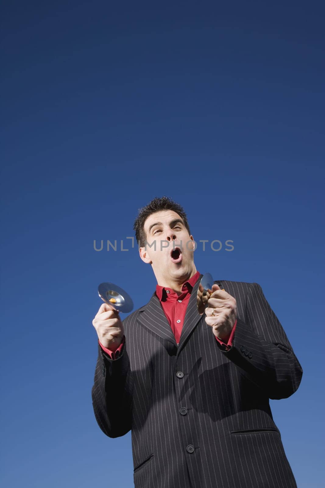 Man playing child size cymbals and singing