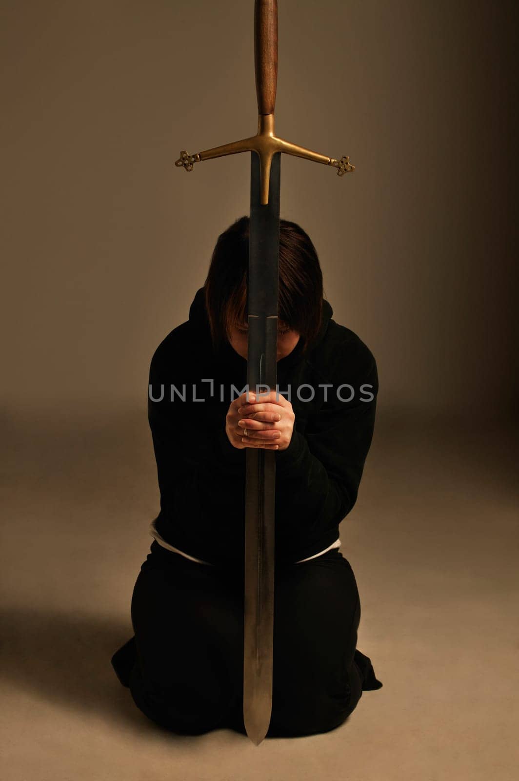 Person kneeling with a sword