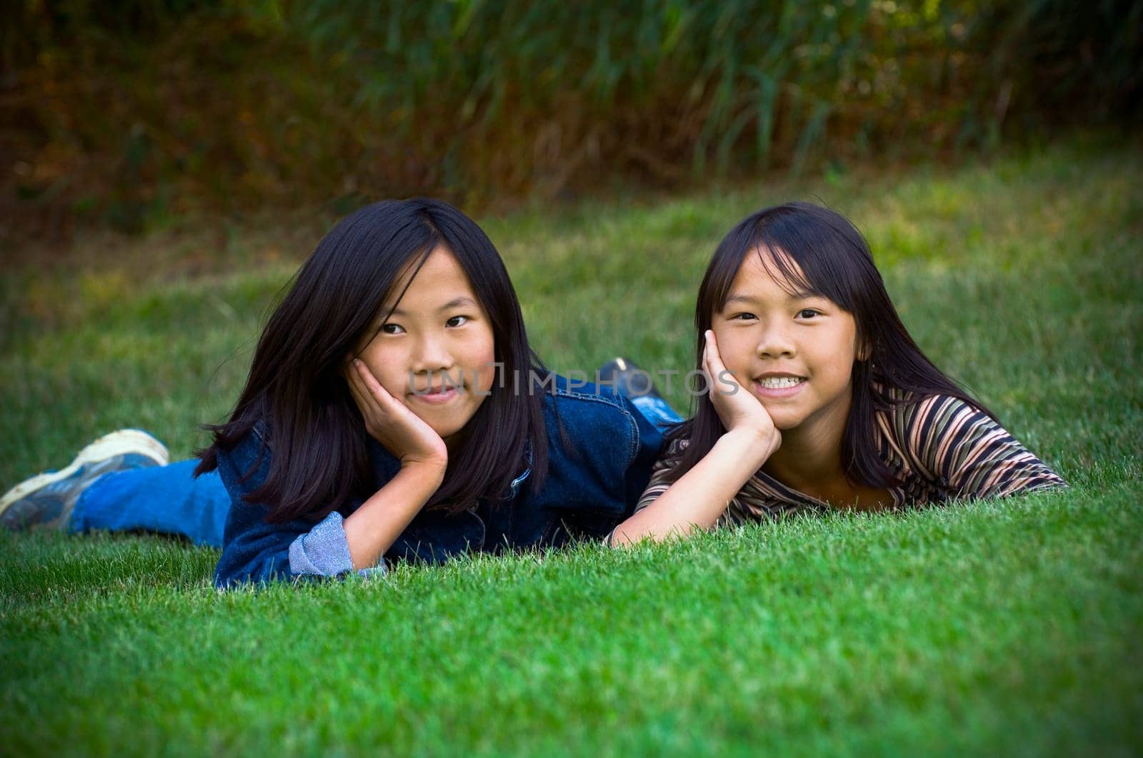 Two sisters lying in the grass