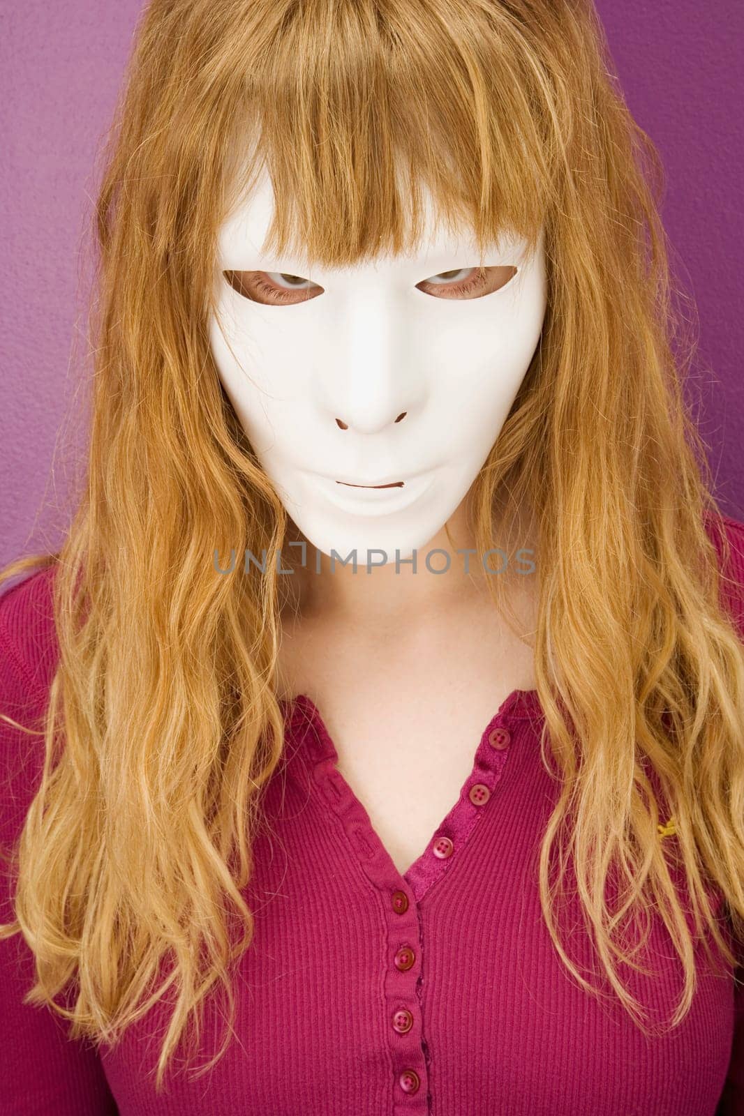 Woman peering angrily behind mask