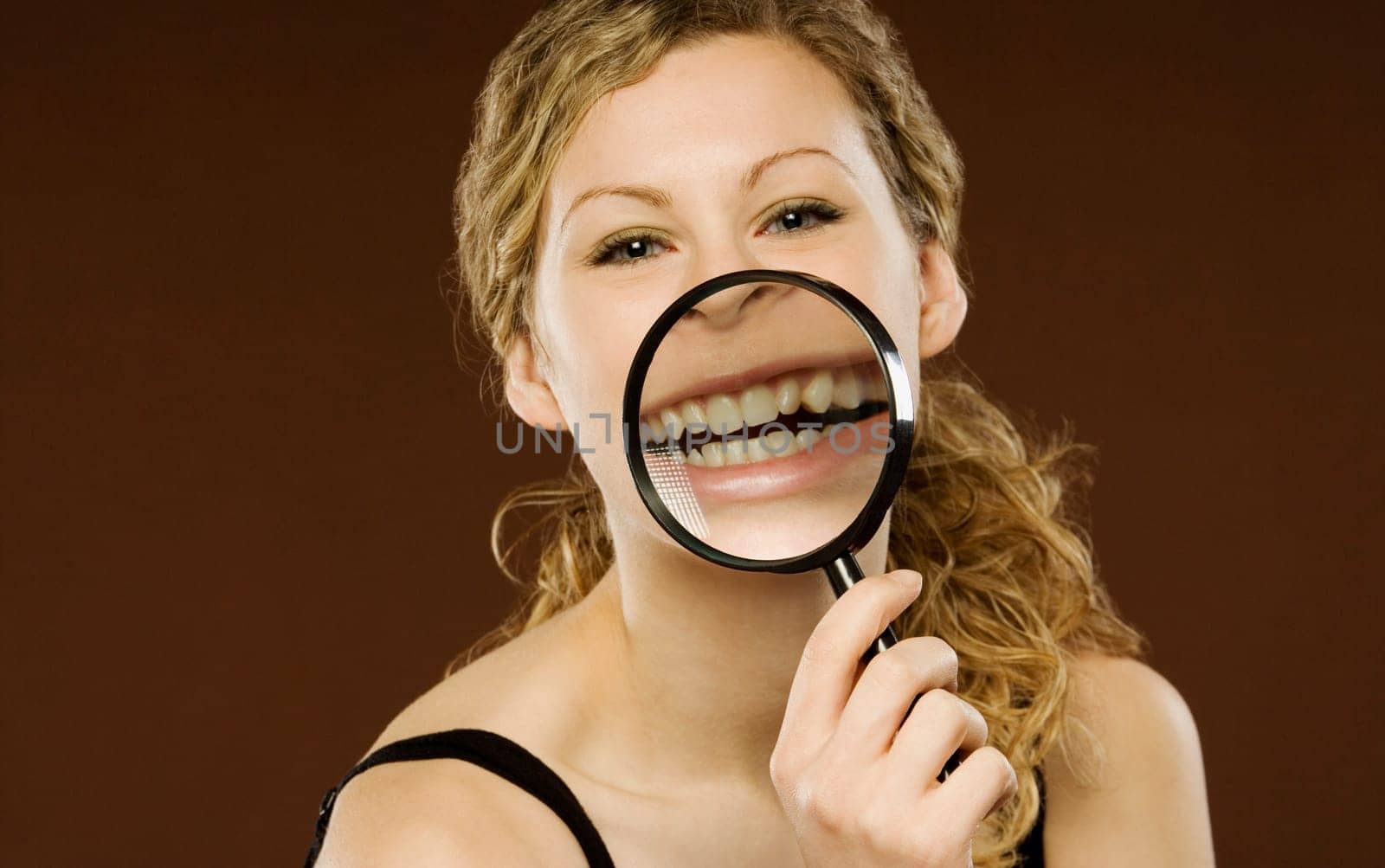 Woman with magnifying glass over her mouth