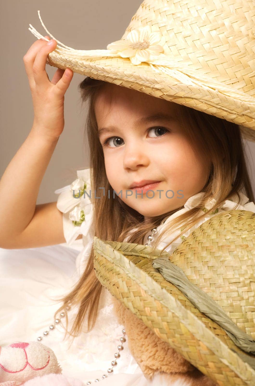Girl and teddy bear wearing straw hats