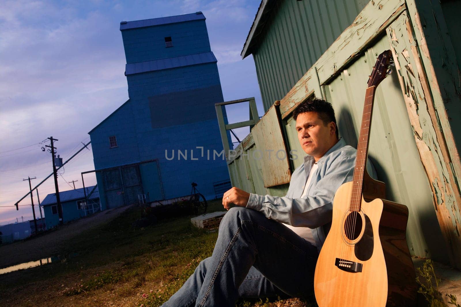 Man sits beside guitar