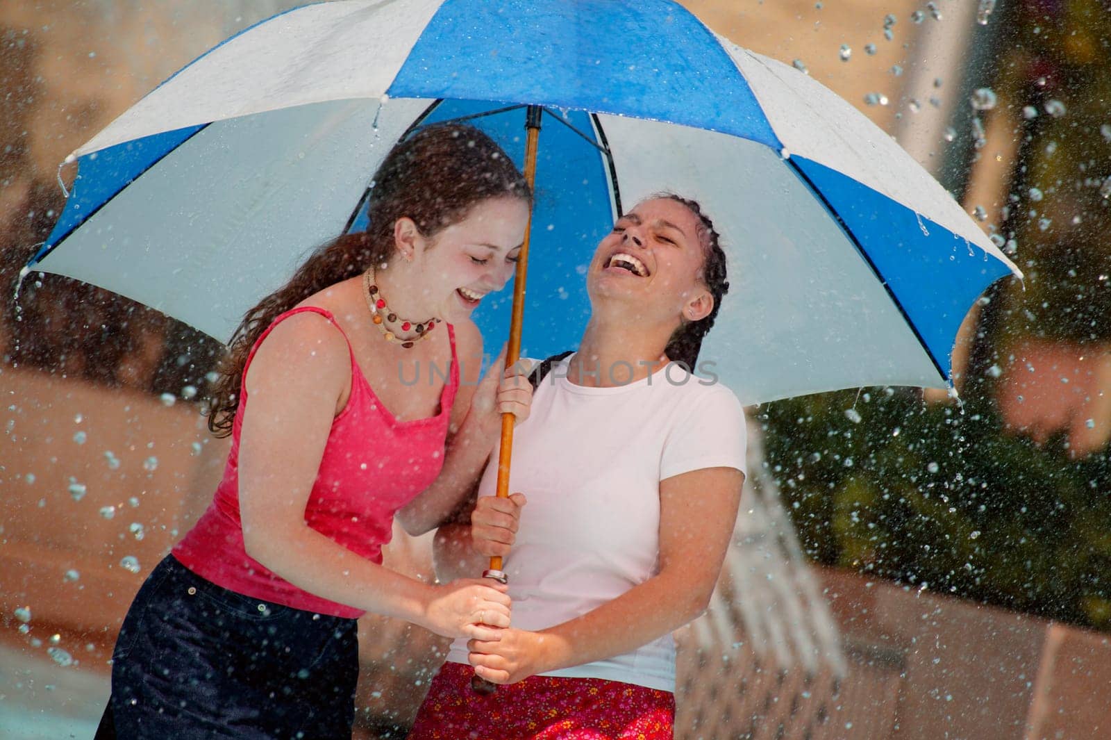 Two girls under an umbrella