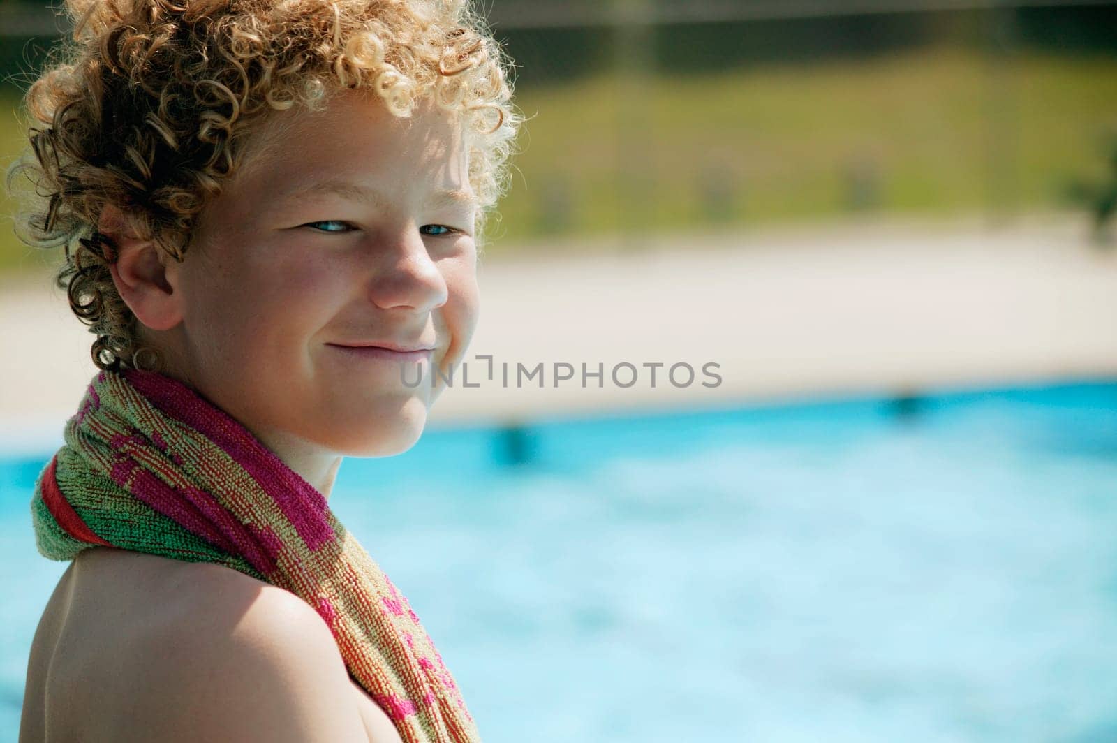 Boy sits beside the pool