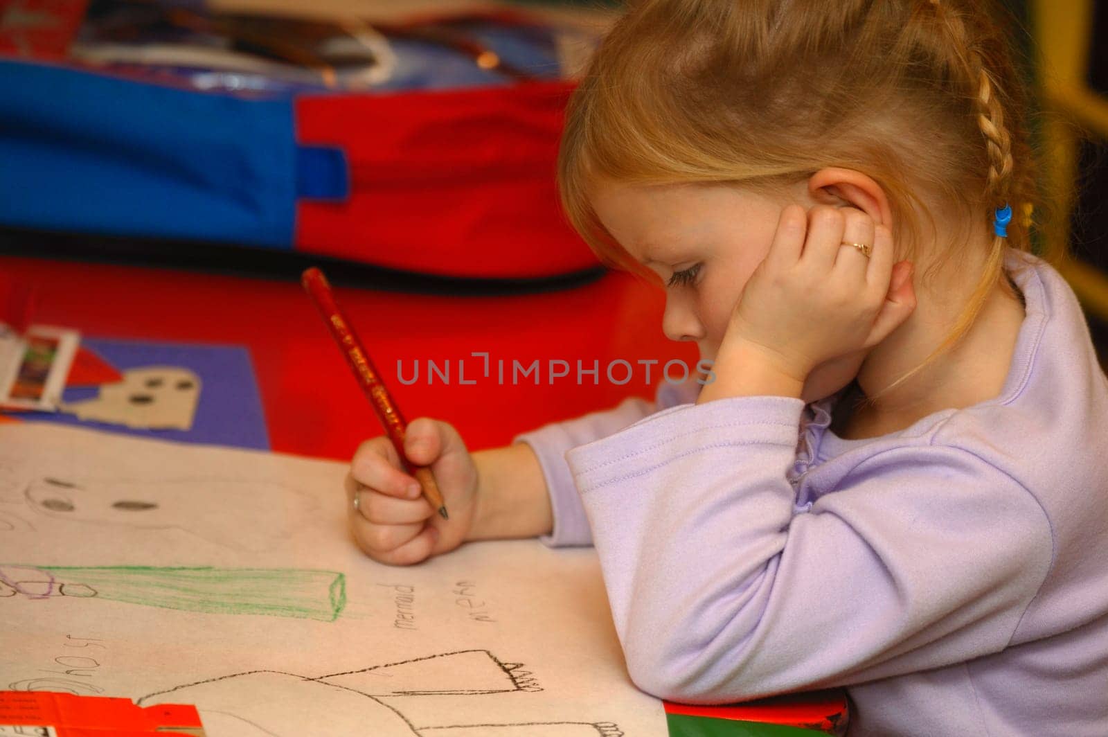 Preschool age girl drawing pictures in kindergarten class