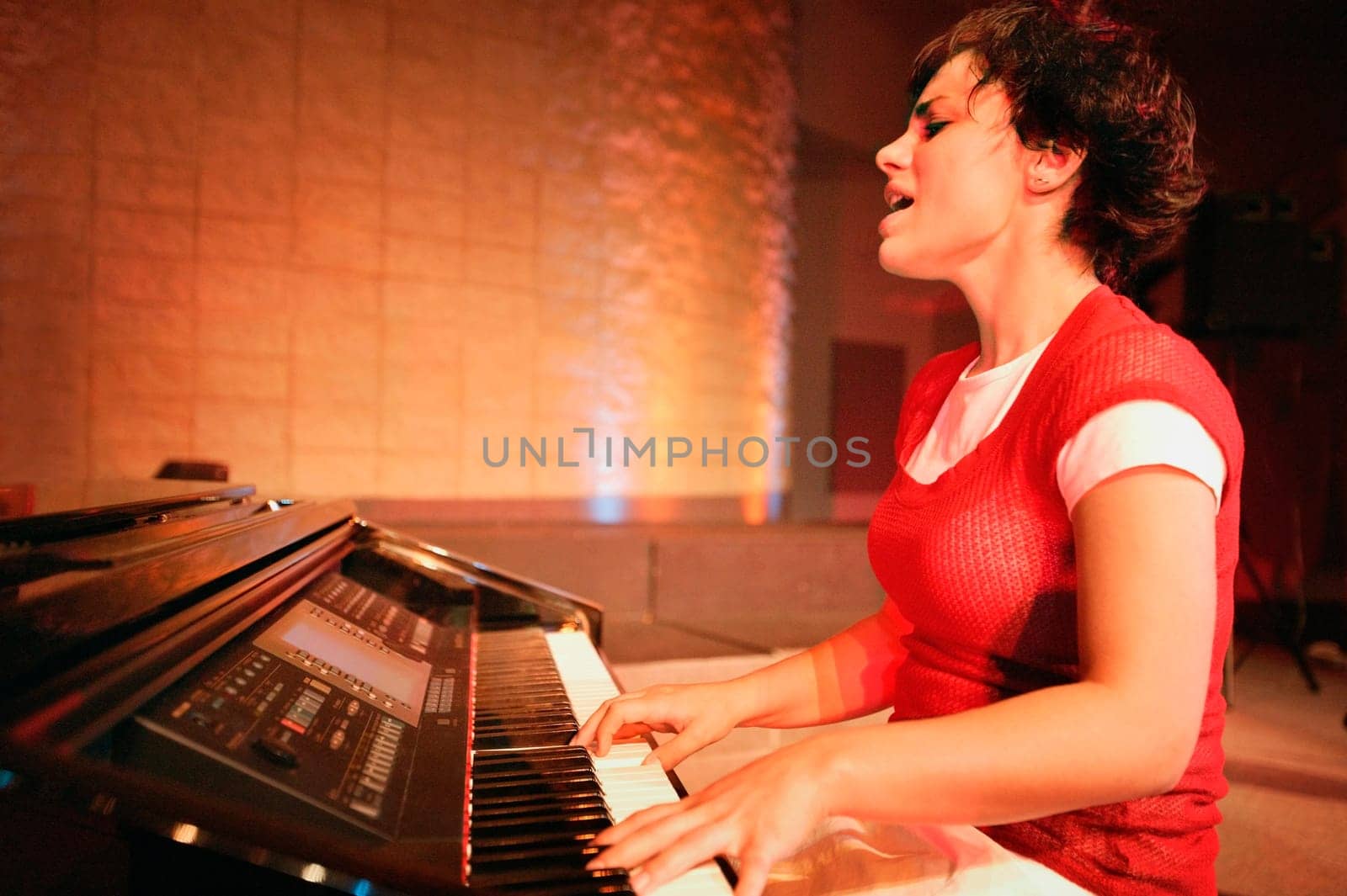 Woman plays the piano and sings
