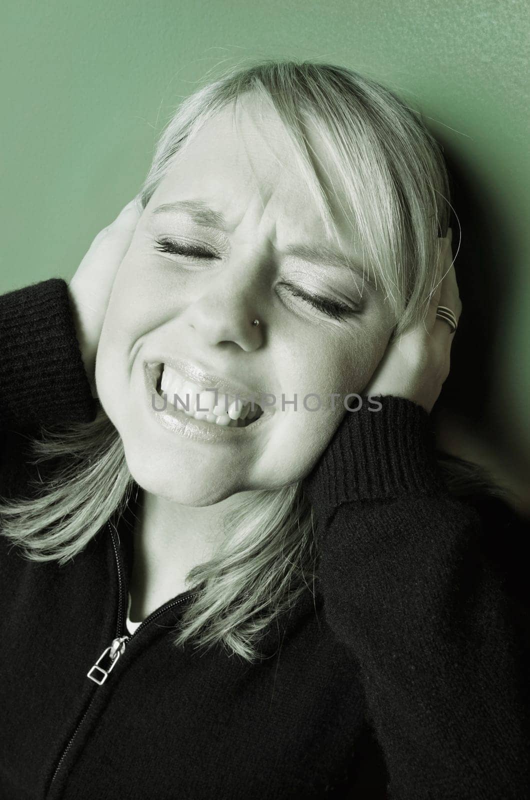 Woman holds hands over her ears