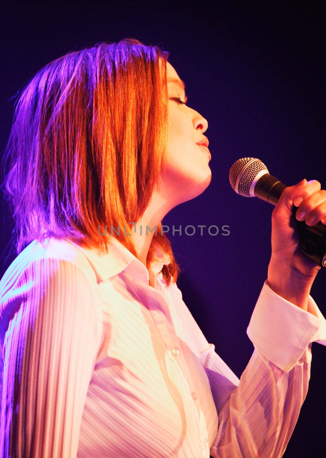A woman sings into a microphone