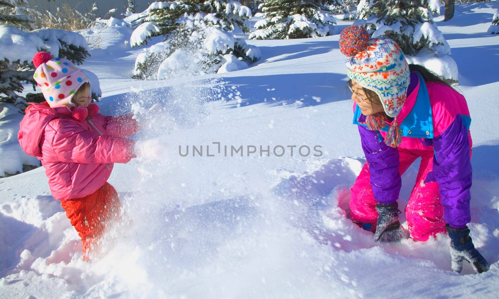 Mother and Daughter having a snowball fight