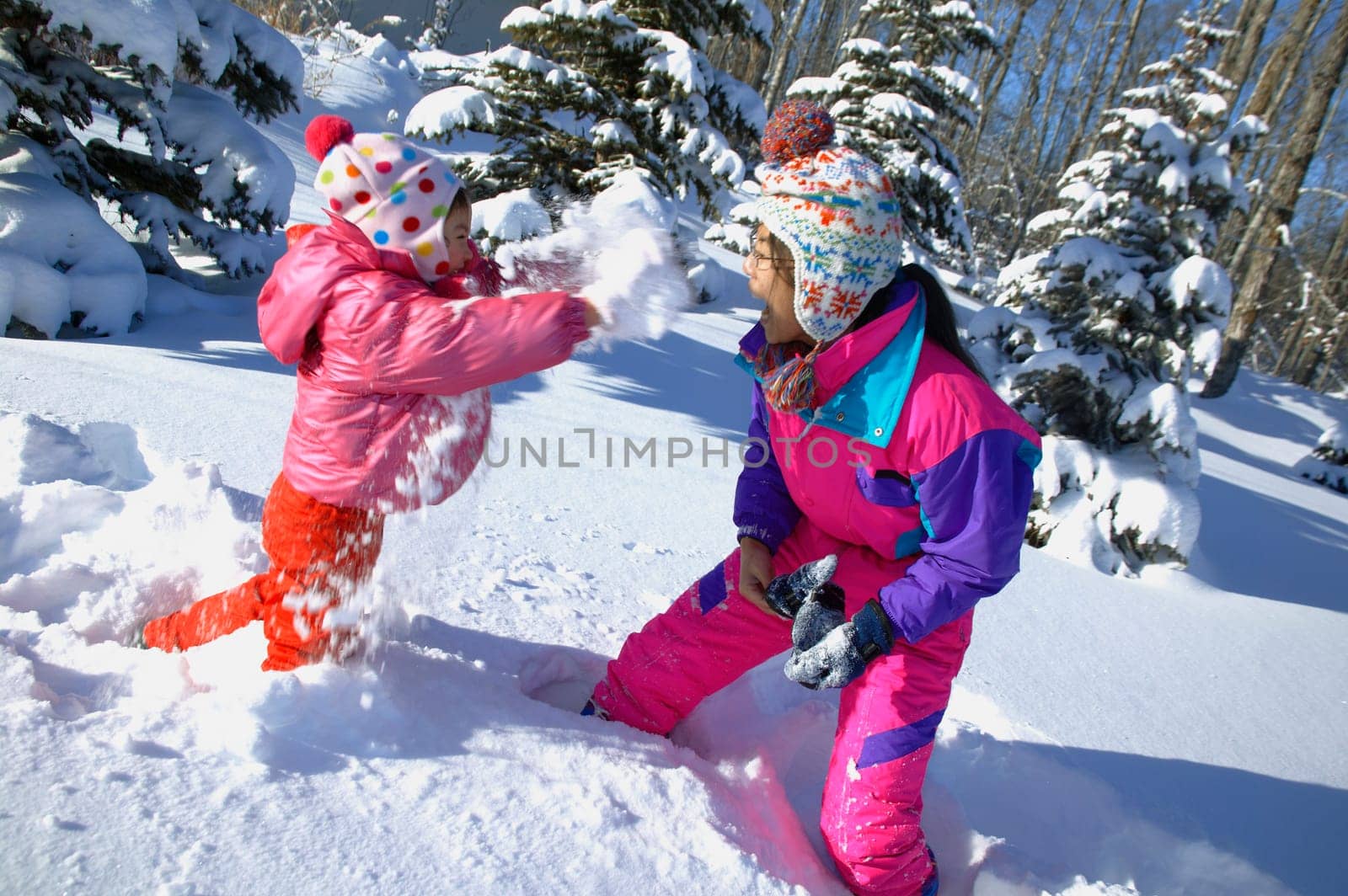 Mother and Daughter having a snowball fight
