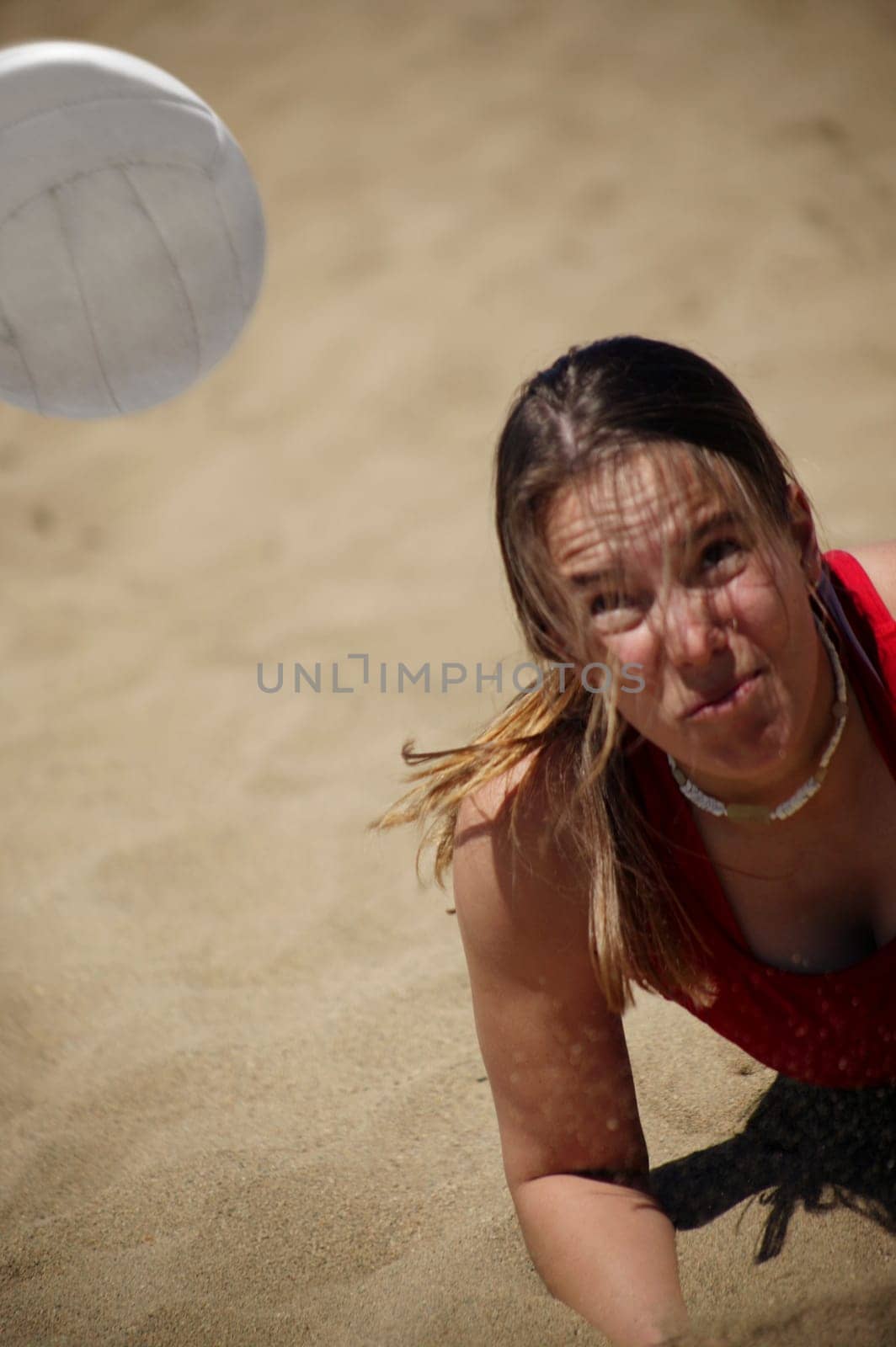 A woman plays beach volleyball