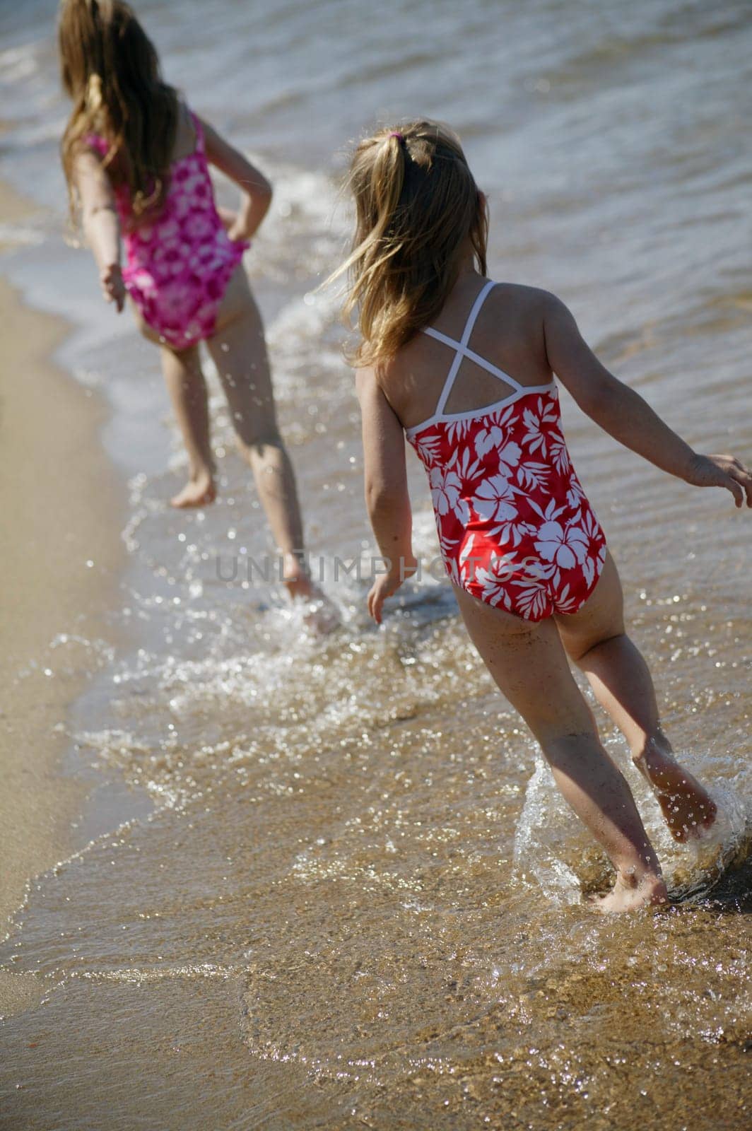 Two children running along the beach