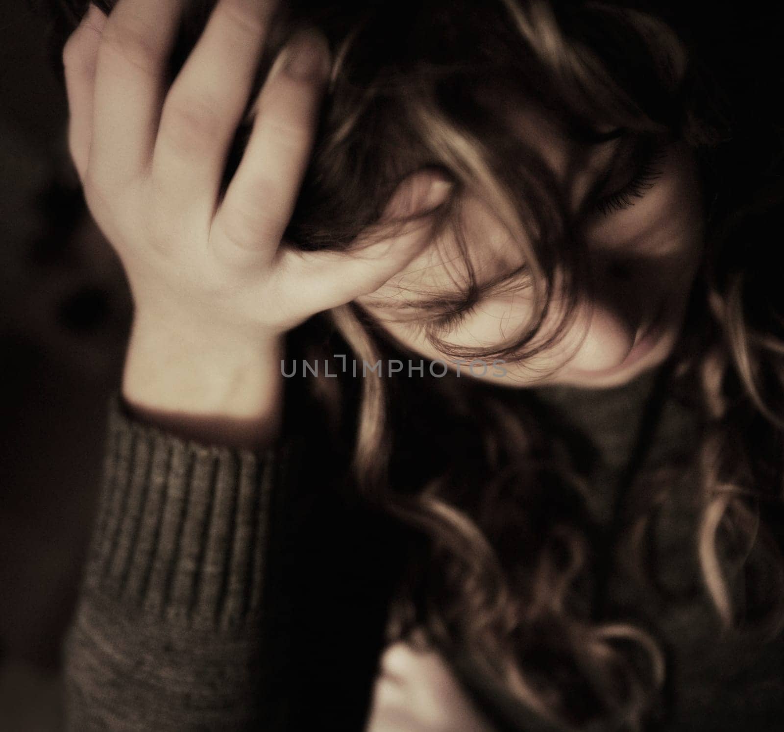 Woman holding head in hand