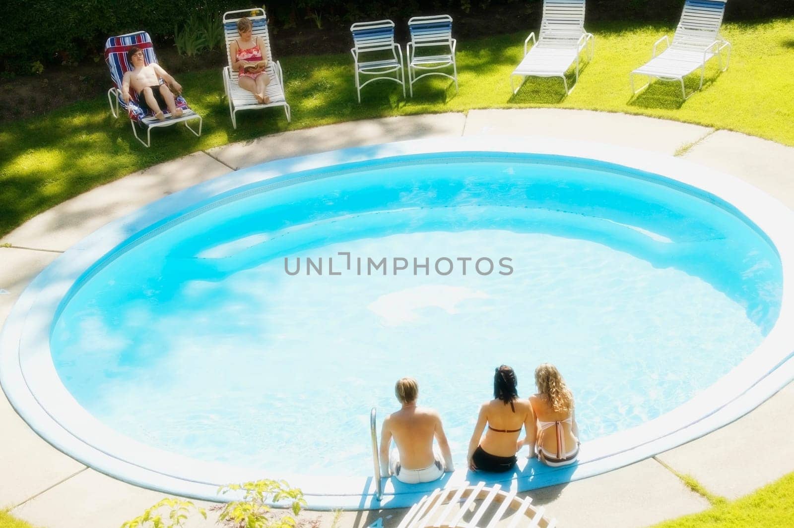 Teens sitting at a pool