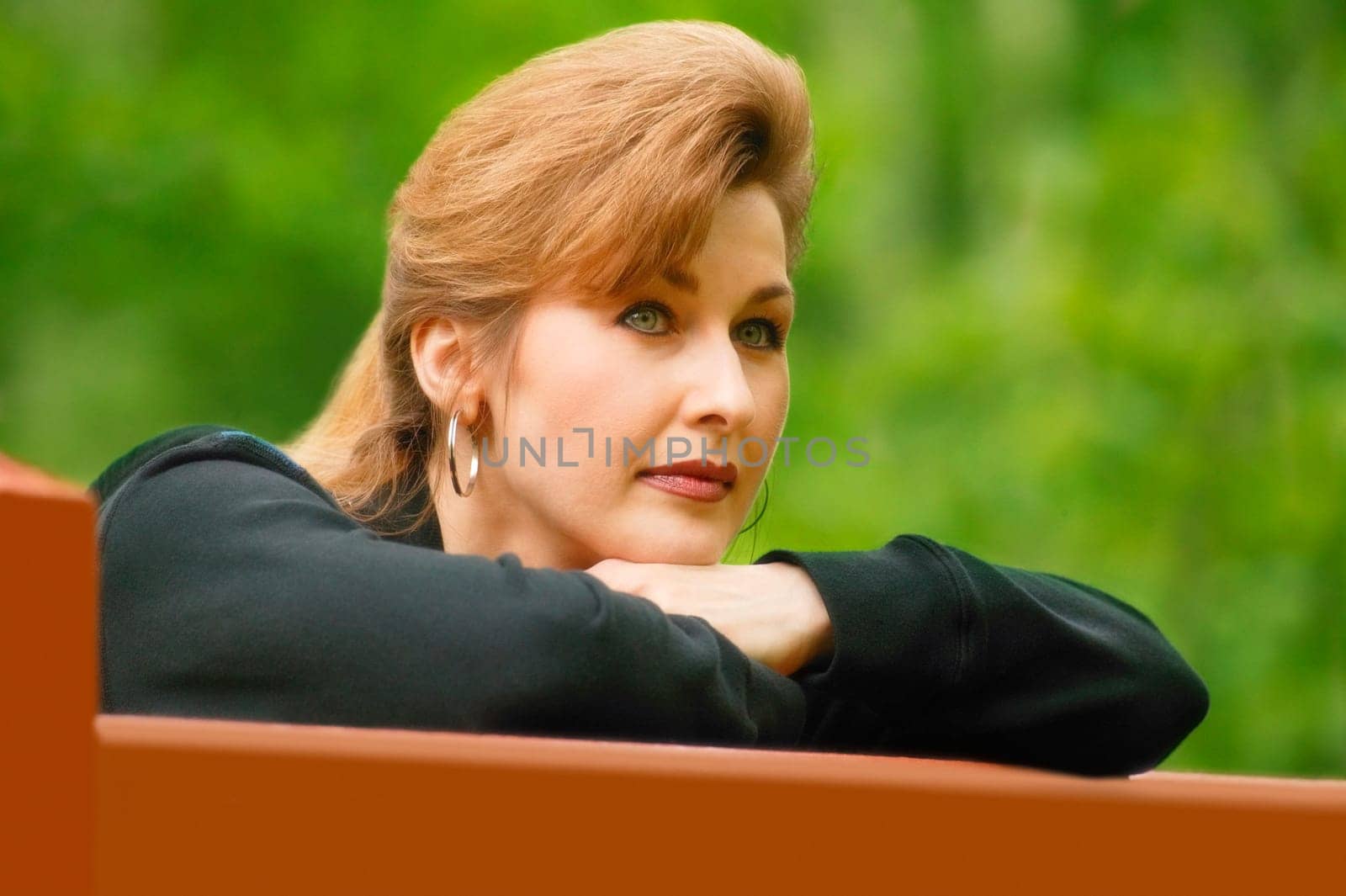 Woman deep in thought leaning on gate
