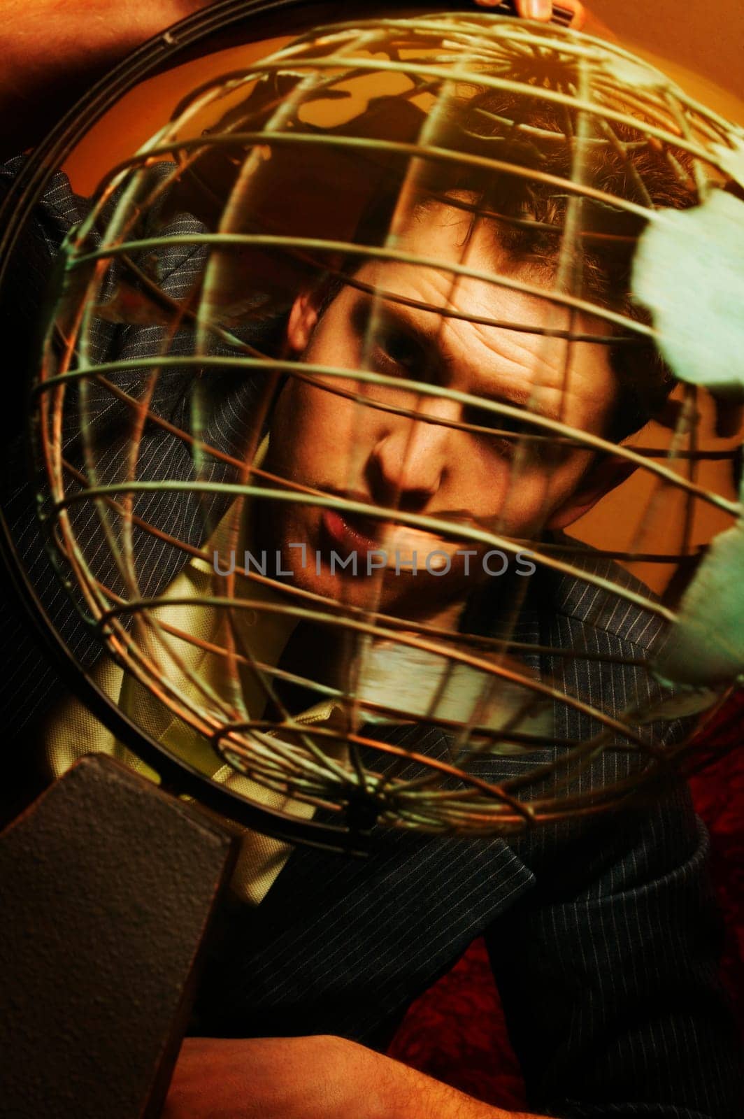Man looking through metal globe