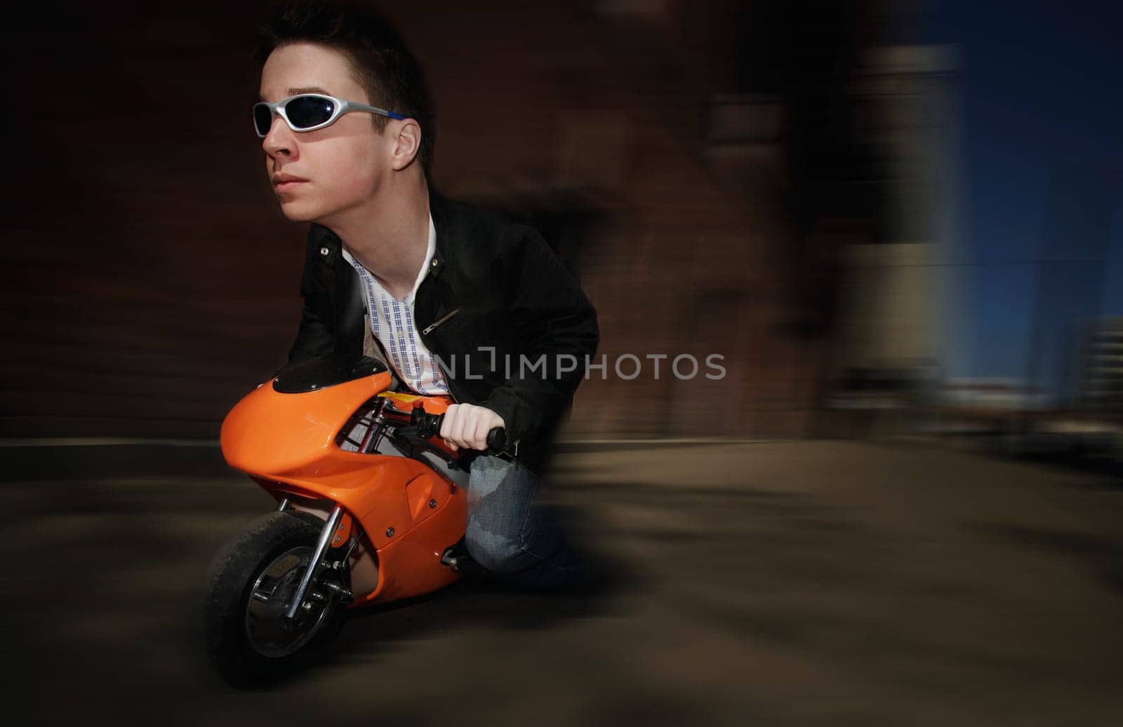 Bizarre image of man riding on a mini motorcycle