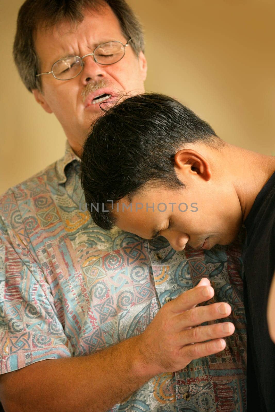 Man praying with teenager