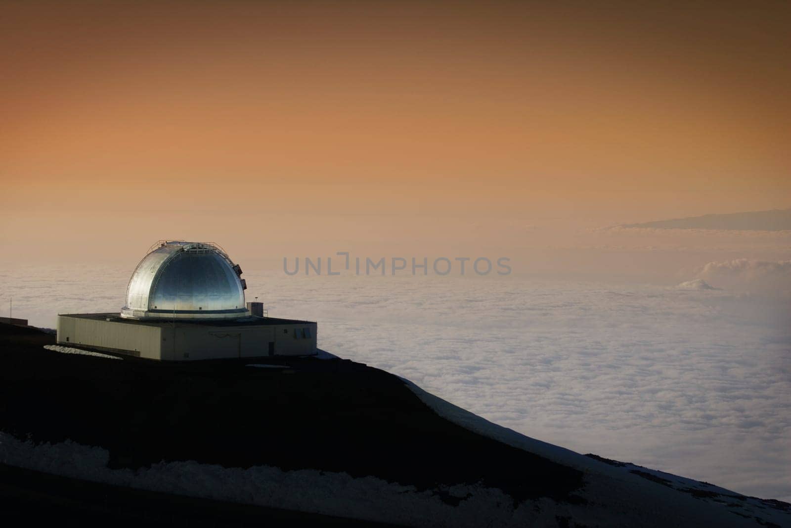 Hawaiian telescope looking over clouded landscape below