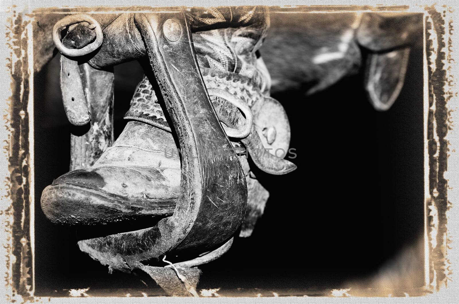 A black and white photo of a cowboy boot and stirrup