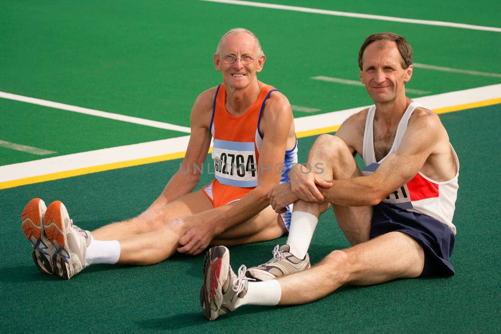 Two athletes resting at the track