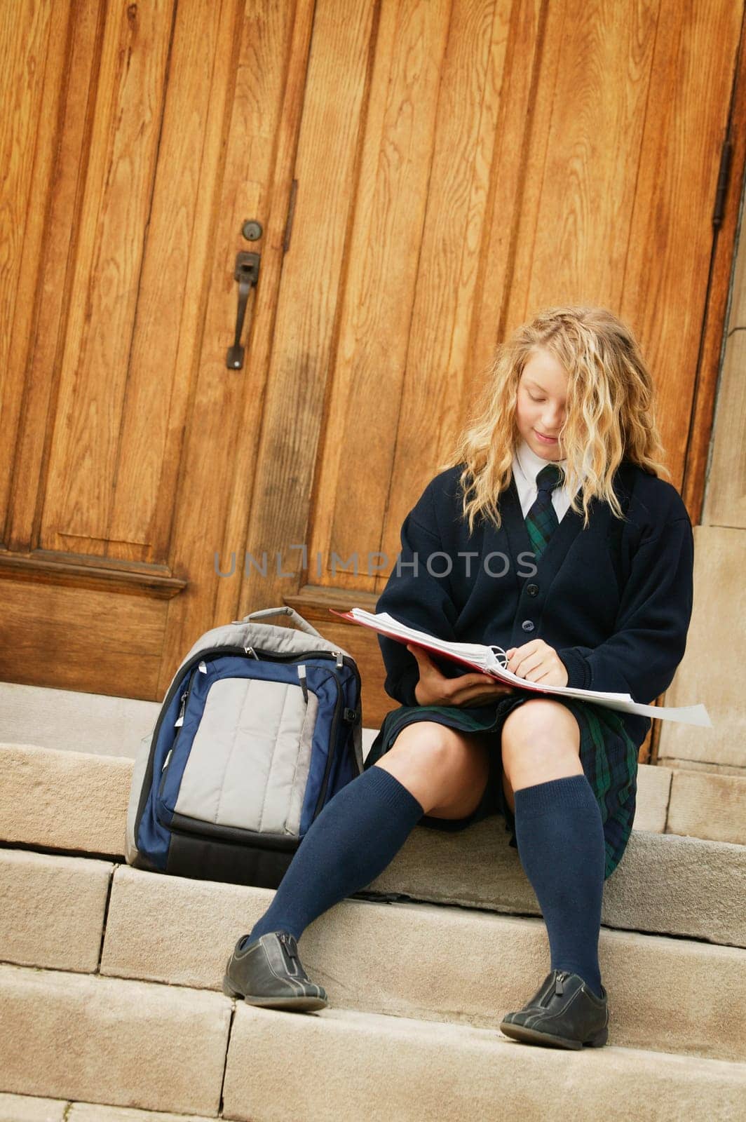 A teenage girl wearing a school uniform studying