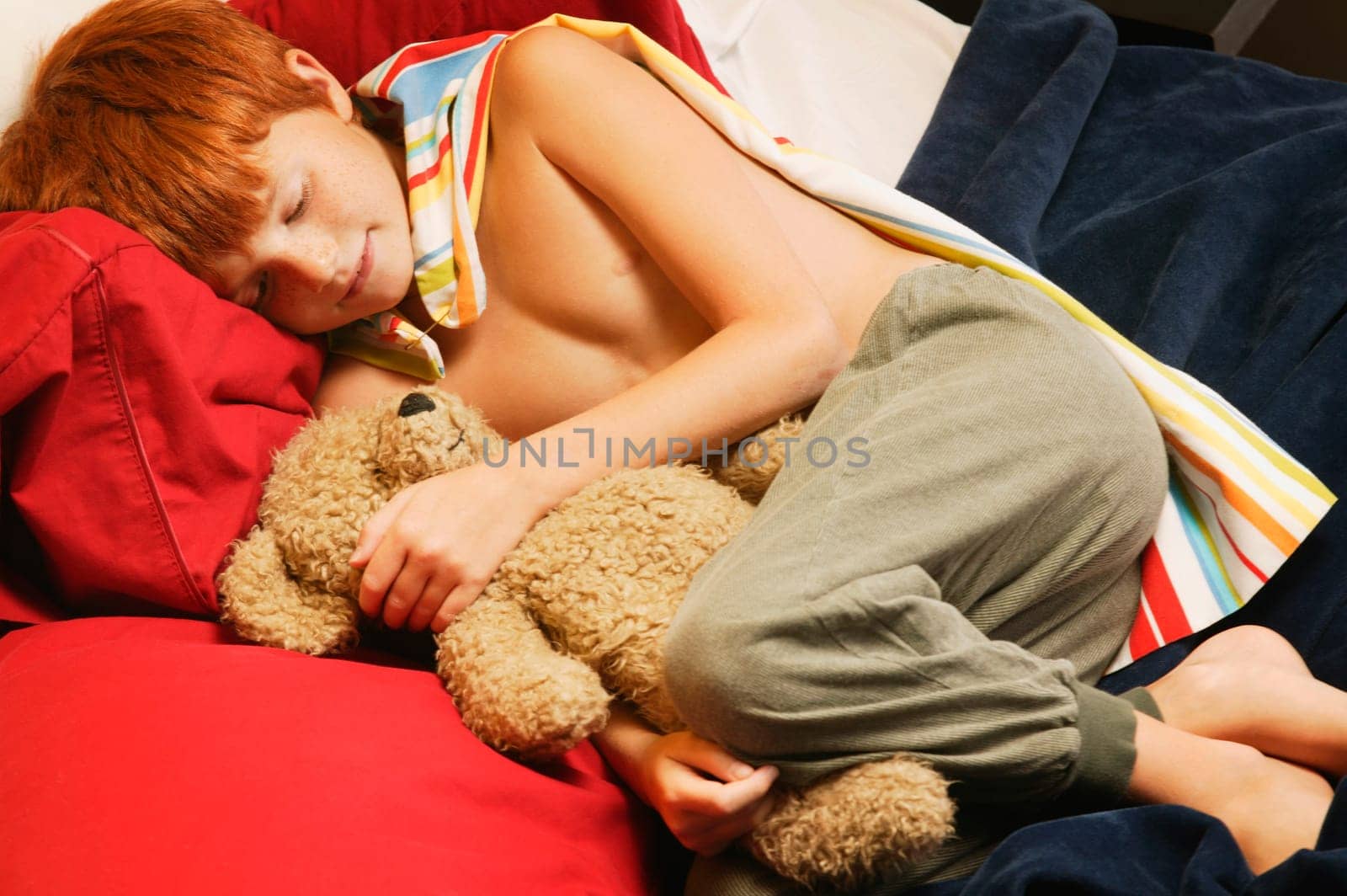 Young super hero sleeping with teddy bear