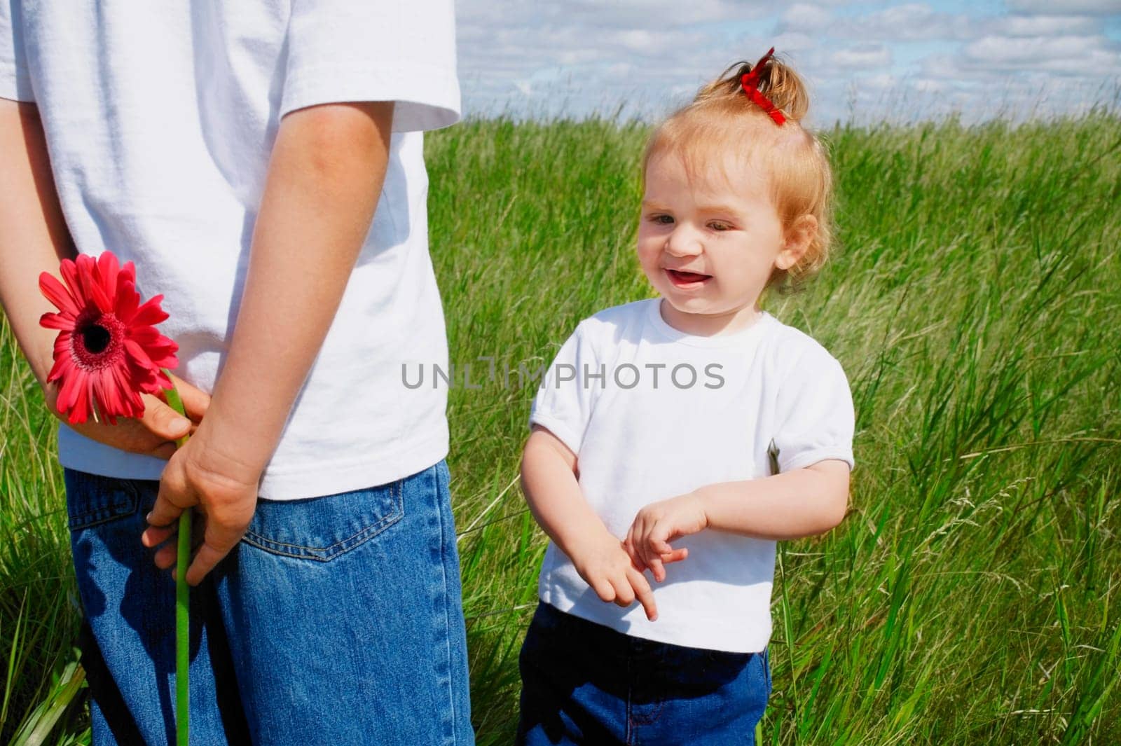 Boy holds a flower behind his back