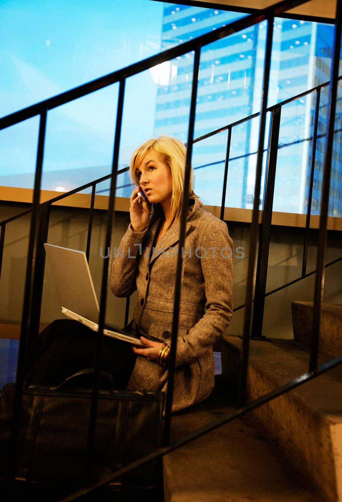 Woman on cell phone and lap top computer