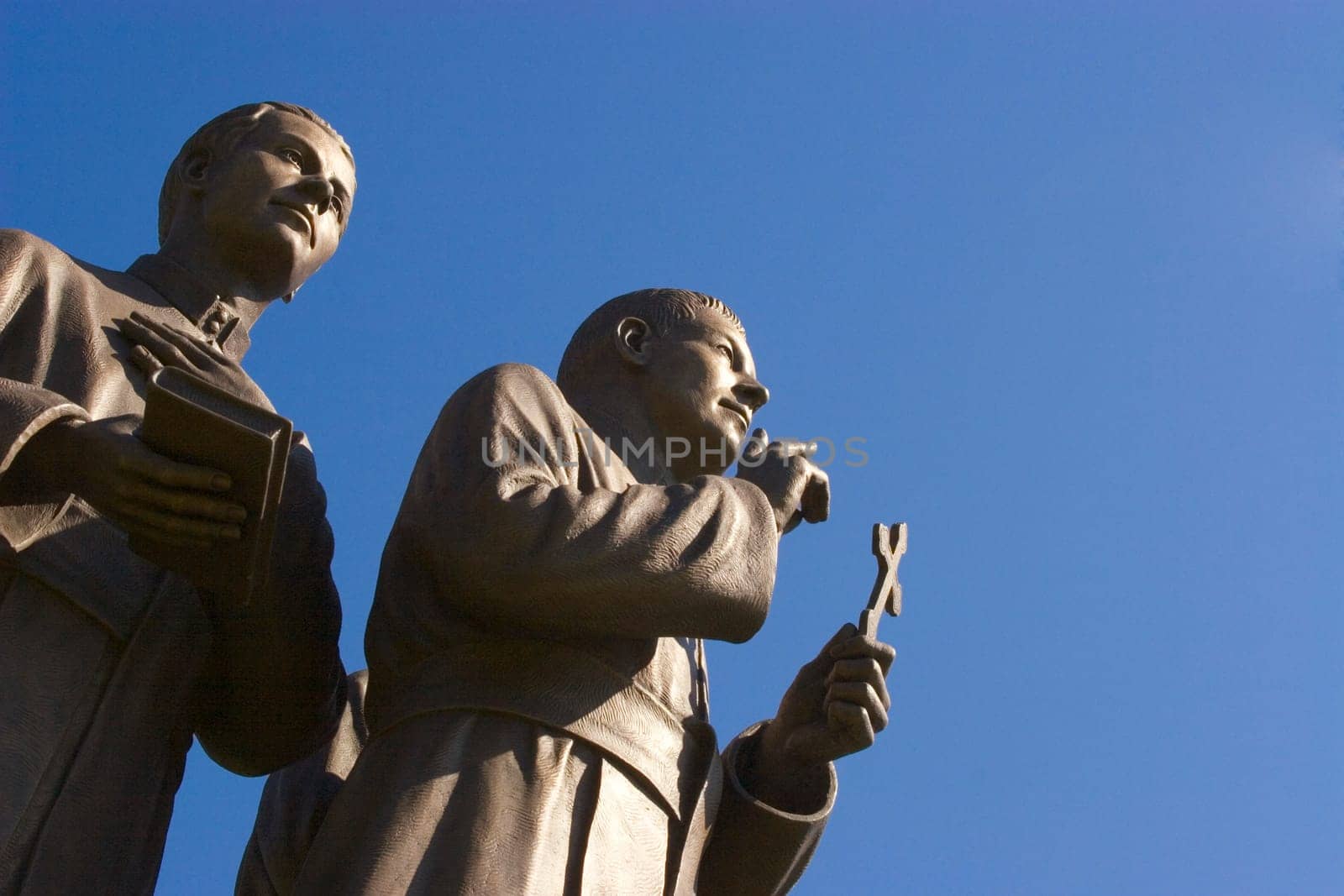 Statue of two men holding cross and book