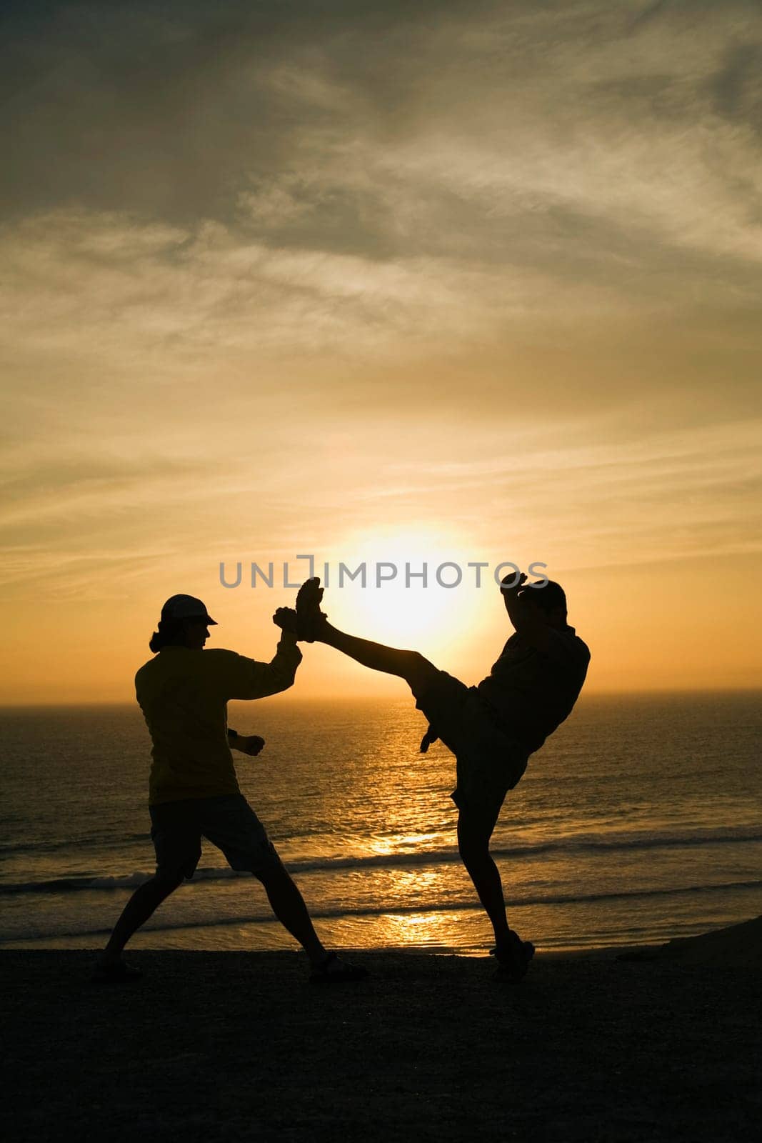Two men fighting on a beach