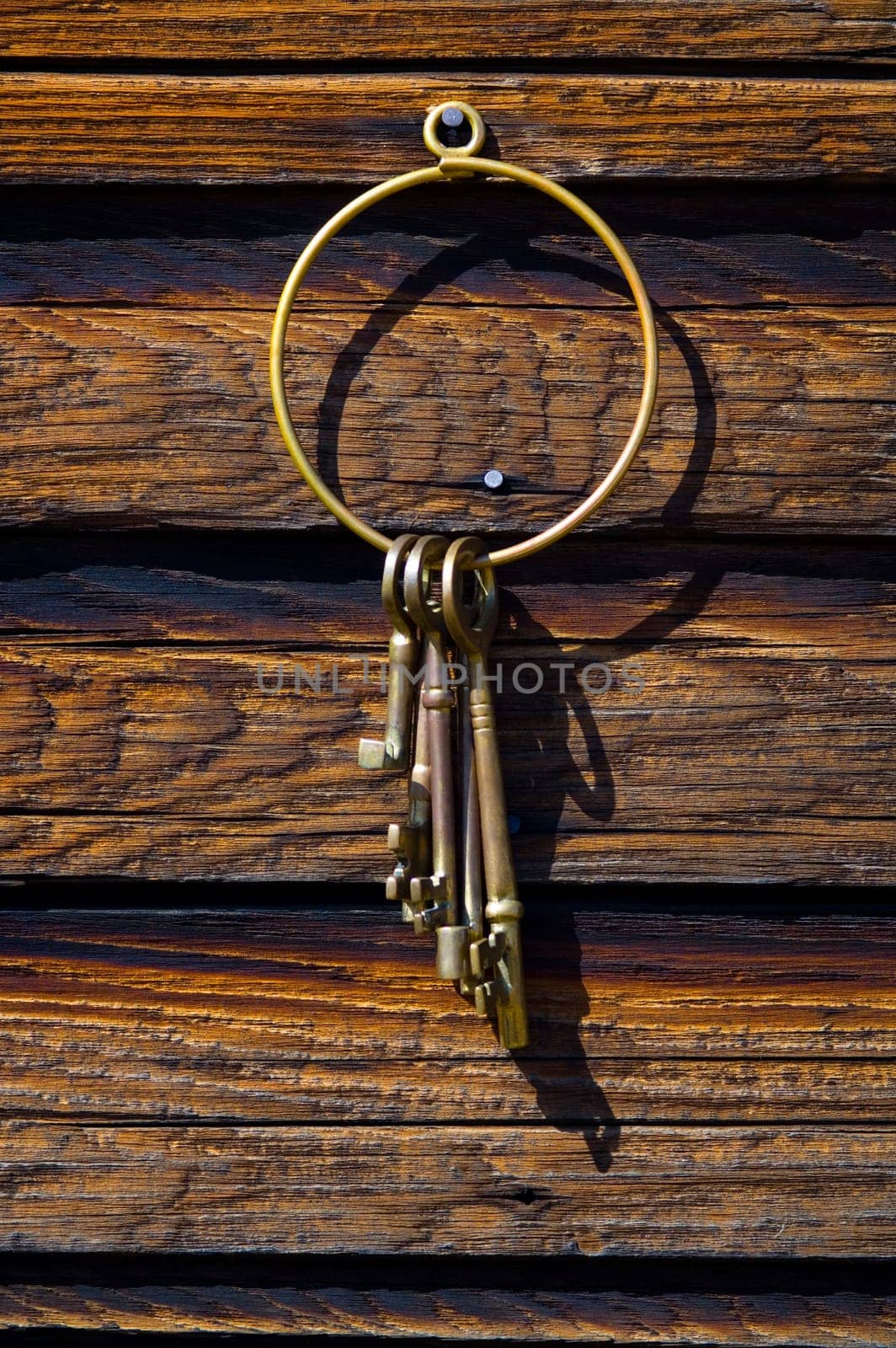 Old-fashioned keys hanging on log wall