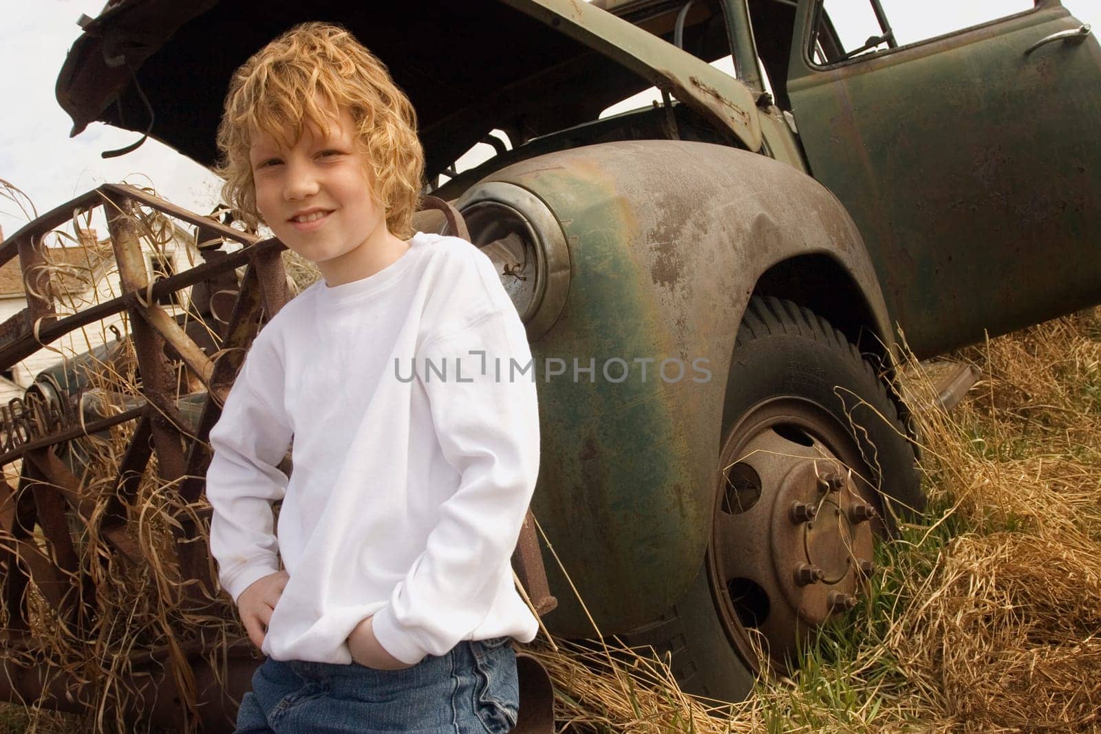 Child beside a rusted vehicle