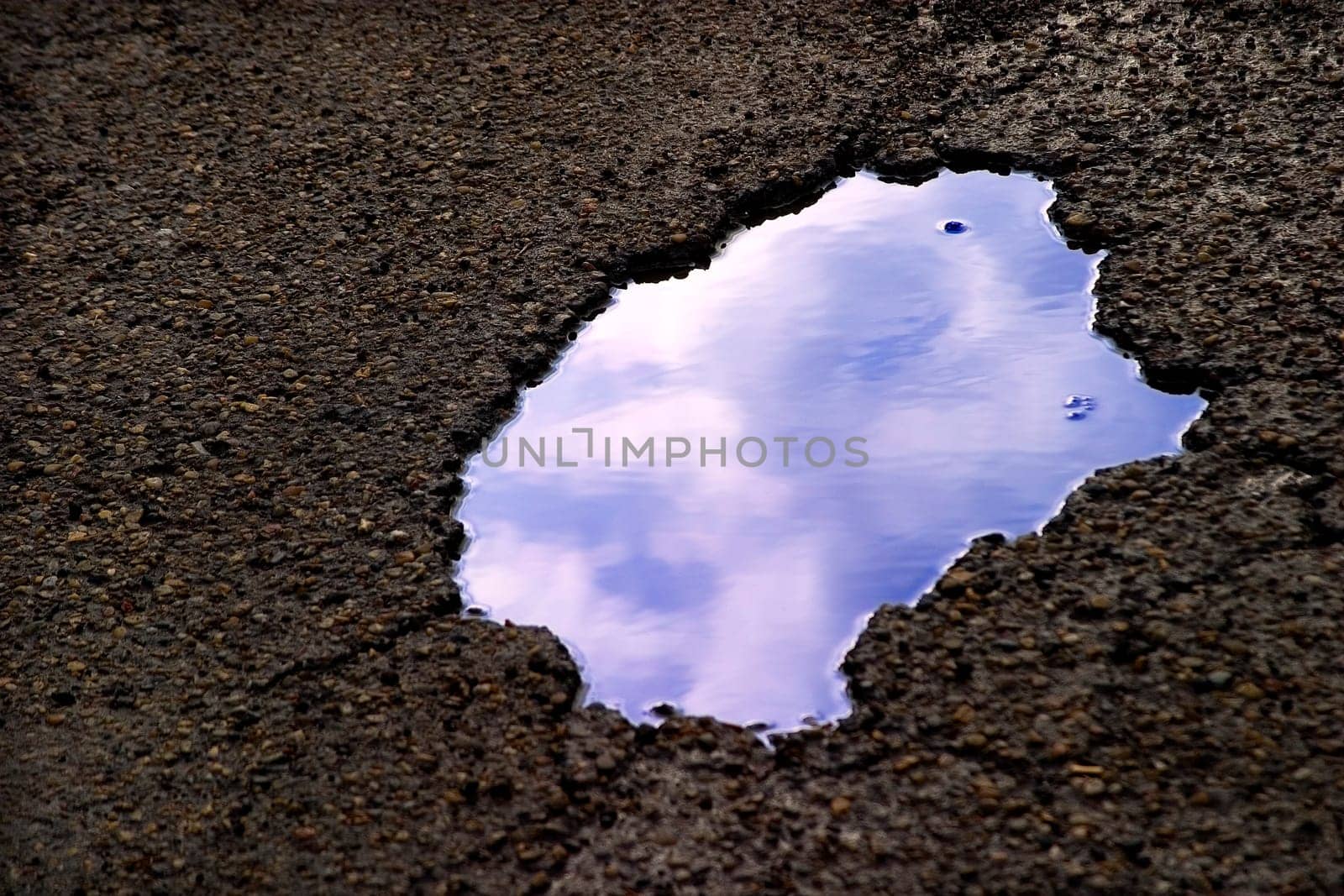Clouds reflecting in puddle