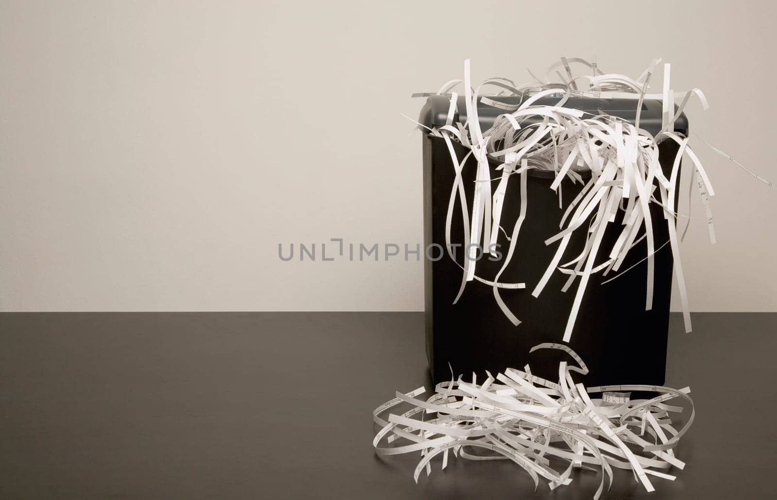 Overflowing garbage can with shredded paper
