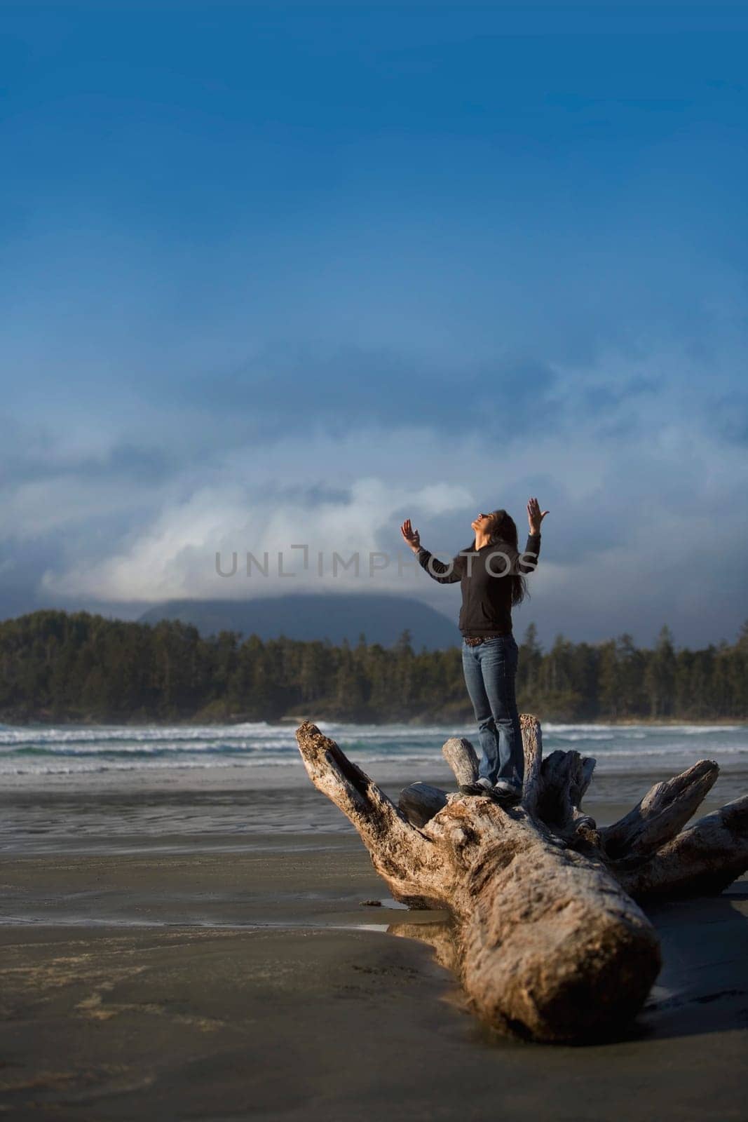 Woman with raised hands on the beach