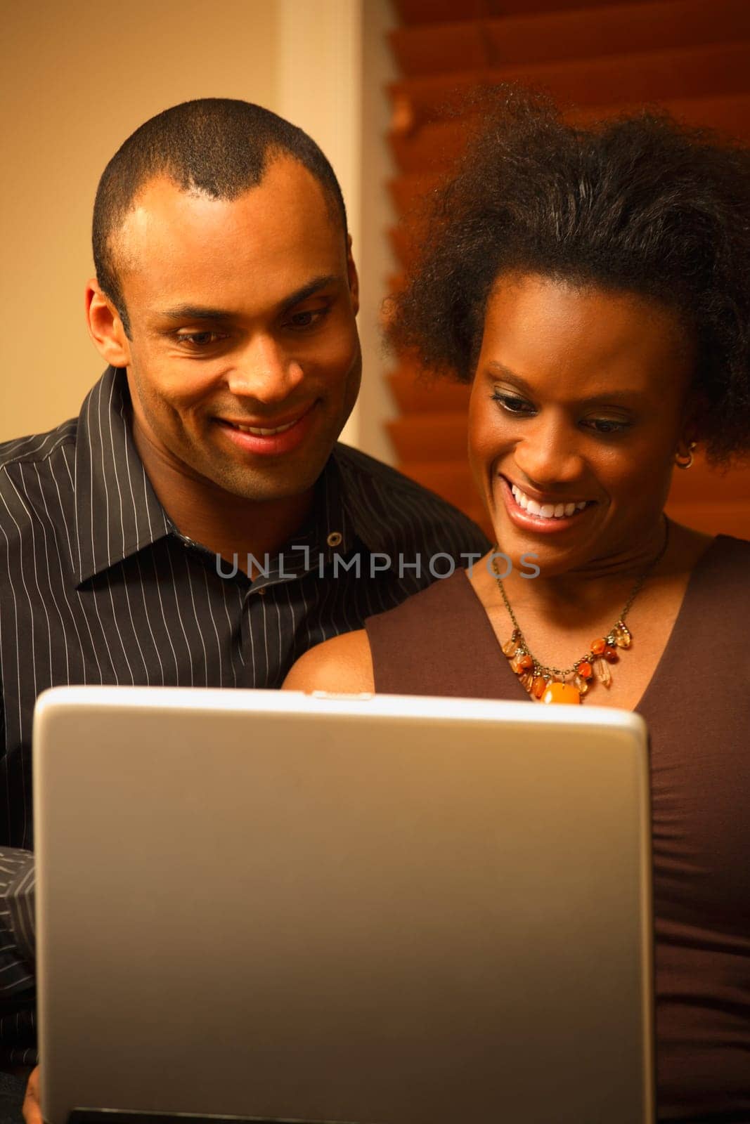 A couple views a laptop screen together